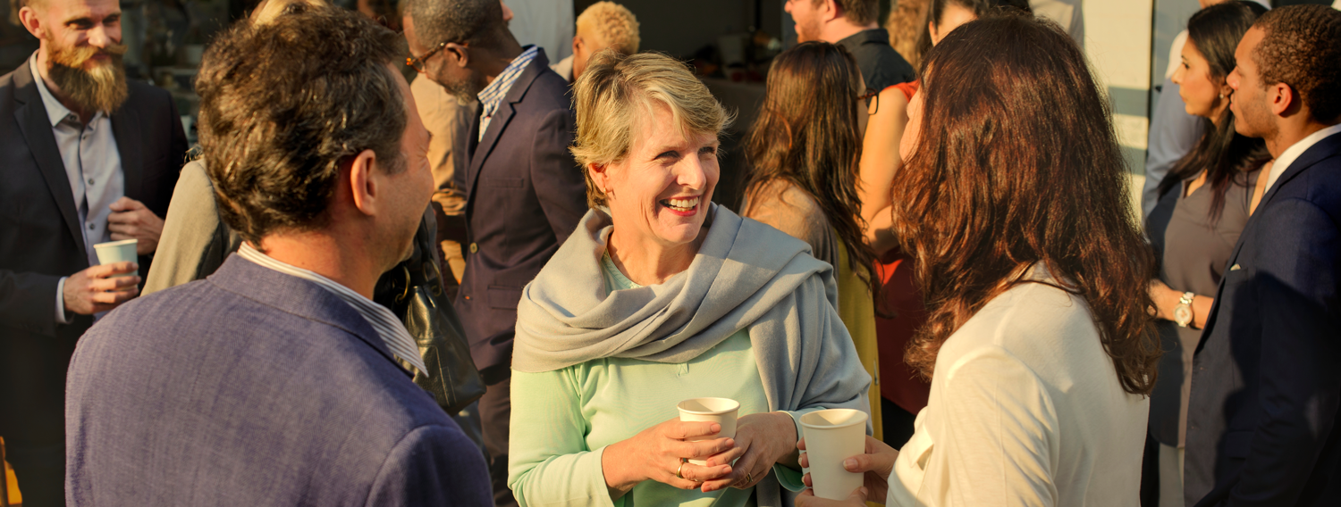 Smiling women having a conversation in a crowd of people