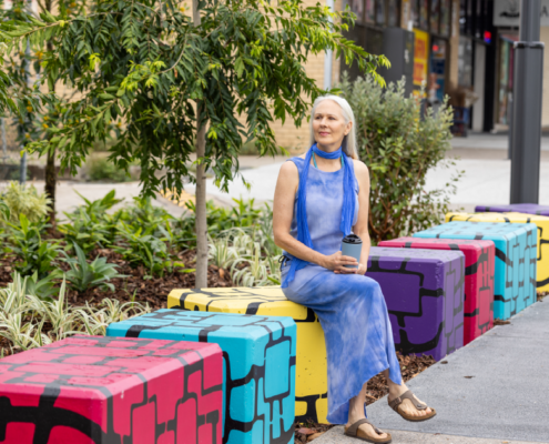 Lady sitting on an artistic concrete block on Croydon Road