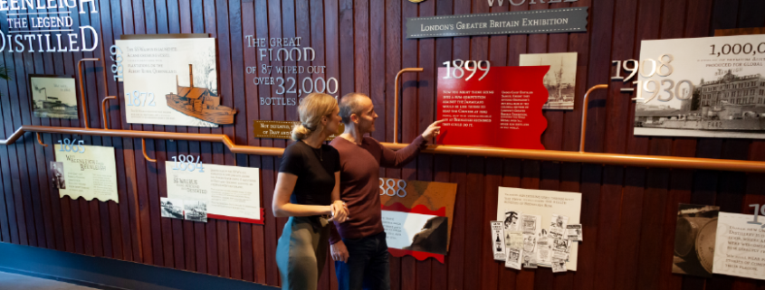 Couple walking and looking through the history wall at Beenleigh Artisan Distillery